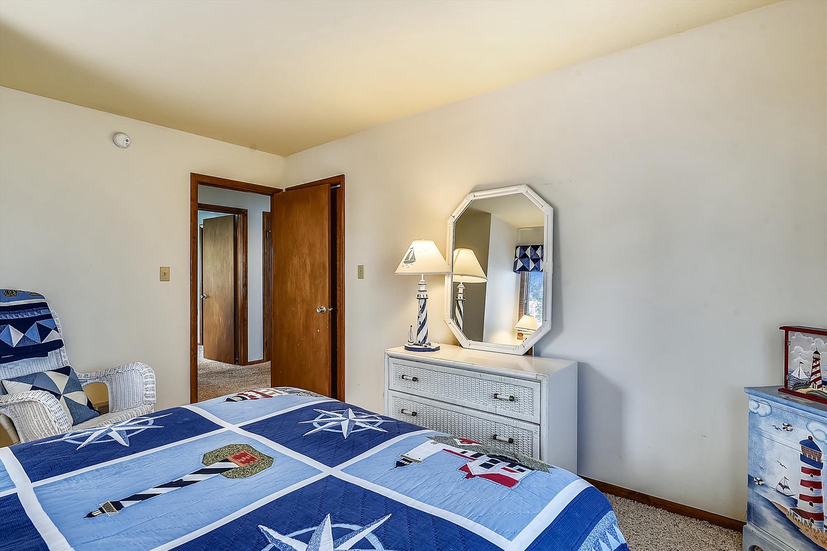 Bright bedroom with charming nautical touches where you'll drift off to sleep under coastal-themed quilts after a day of exploring the area.