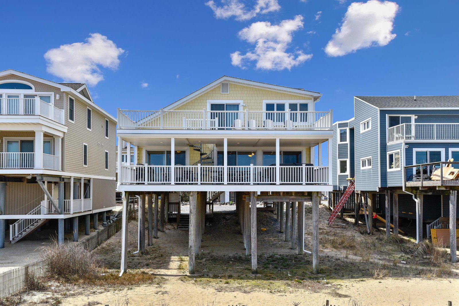 Elevated coastal architecture designed for beachside living, set on sturdy pilings with spacious covered porches and balconies in a quiet neighborhood.
