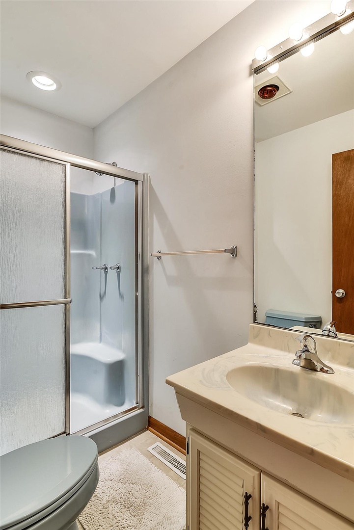 Your private bathroom awaits with a clean, functional layout featuring a spacious shower, fresh towels, and everything you need to refresh after a day of exploring.