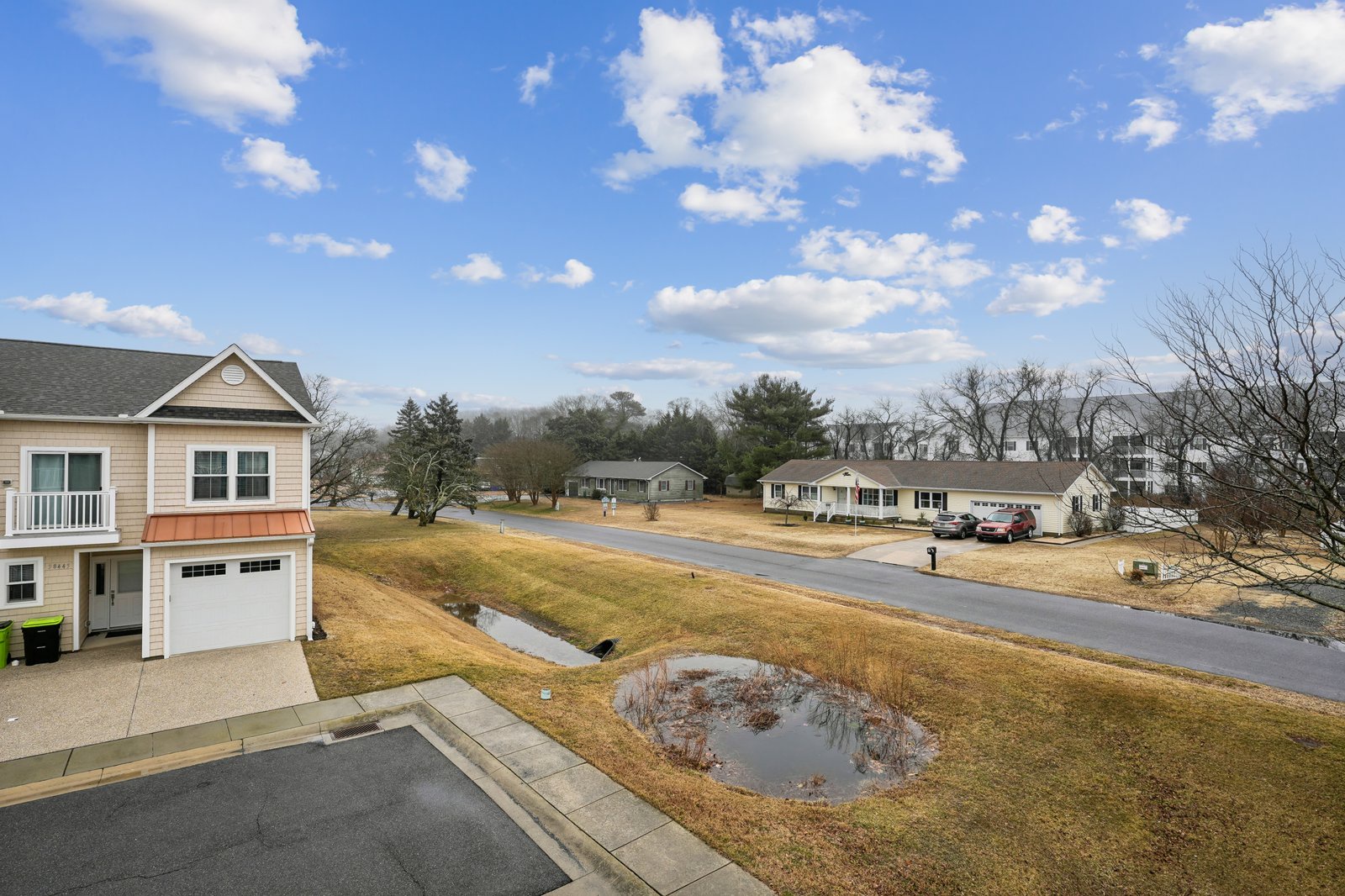 Peaceful residential neighborhood with well-maintained properties and quiet tree-lined streets under bright blue skies.