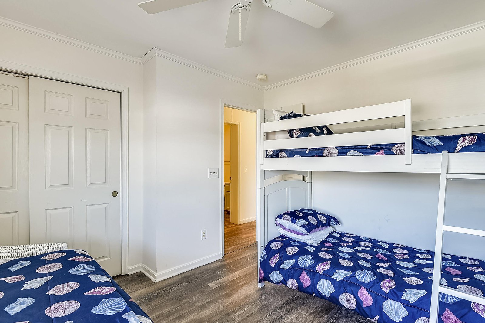 Rest easy in this cheerful bedroom, where nautical-themed bedding and a sturdy bunk bed set the stage for cozy nights and playful mornings together.