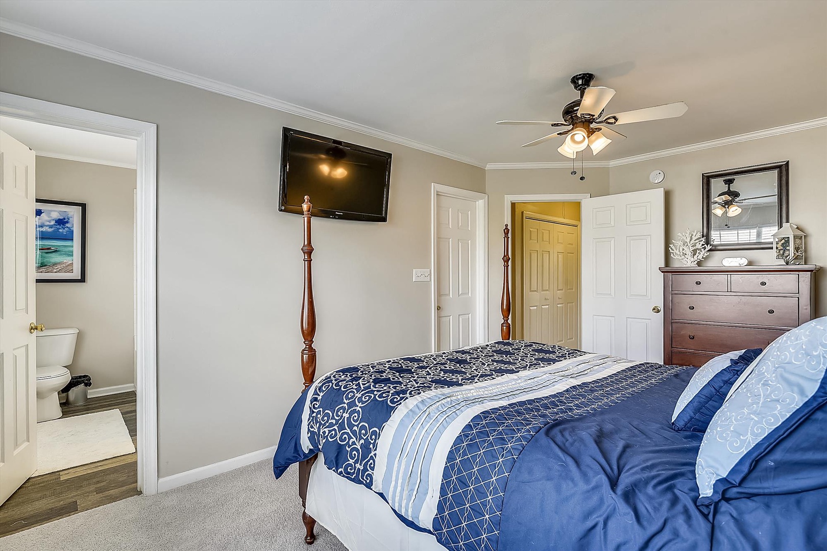 Sink into plush bedding in your serene bedroom, where coastal touches, a ceiling fan, and flatscreen TV create your perfect retreat after a day of exploring.