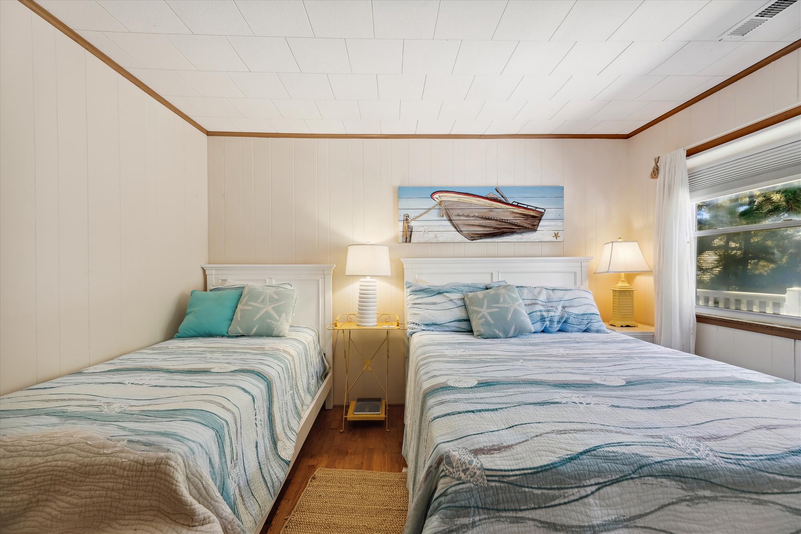 Drift off in coastal comfort—soft, sea-inspired linens and nautical touches invite restful sleep while natural light filters through the window.