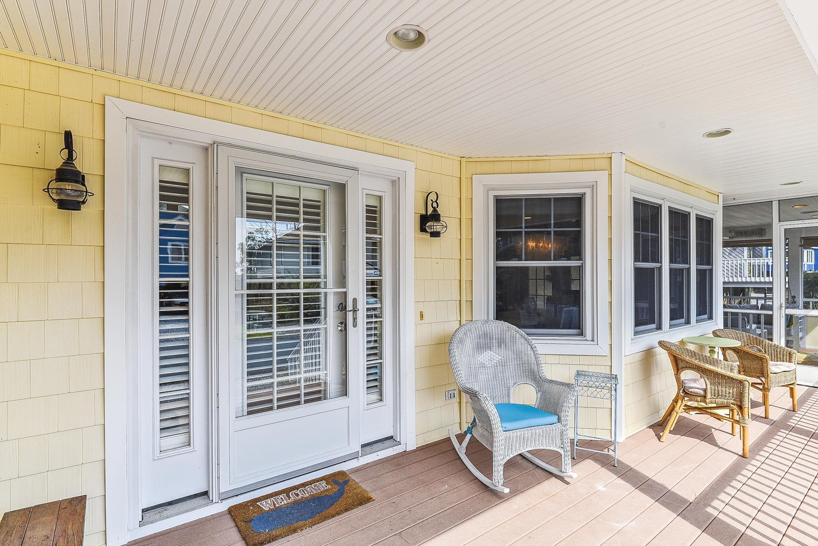 Welcome mat and rocking chair mark the entrance to your coastal retreat, offering a welcoming first impression before you step inside.