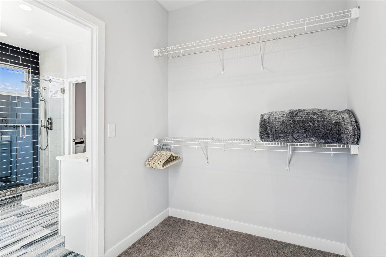 Spacious walk-in closet with thoughtful shelving for all your belongings, conveniently connecting to your private bathroom for effortless morning and evening routines.
