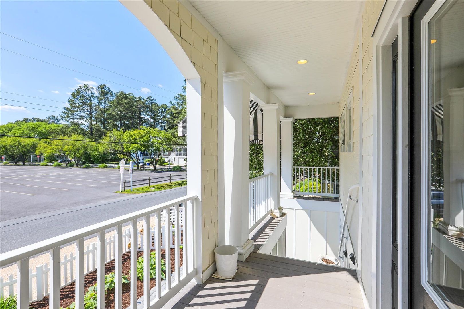 This covered front porch offers a peaceful spot with views of the tree-lined street and surrounding neighborhood, marking your arrival to the property.
