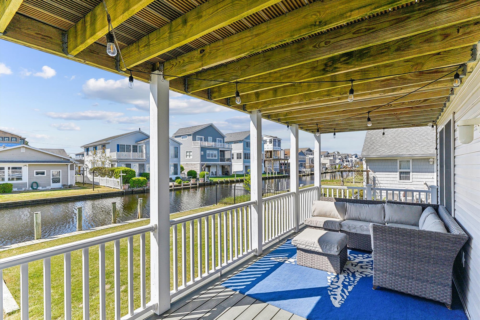 Step out onto your private covered deck and take in serene waterfront views—comfortable seating invites you to relax with morning coffee or unwind as the day fades into evening.