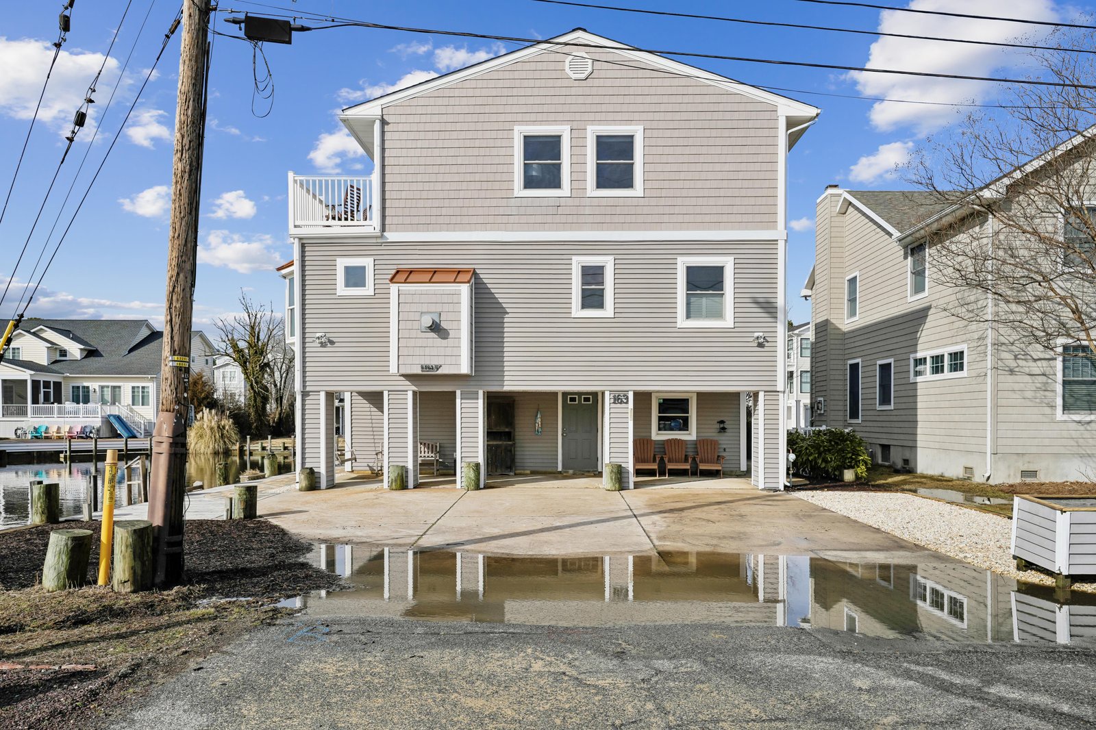 Waterfront property featuring a covered parking area, private dock access, and a second-floor balcony—your ideal coastal retreat awaits.