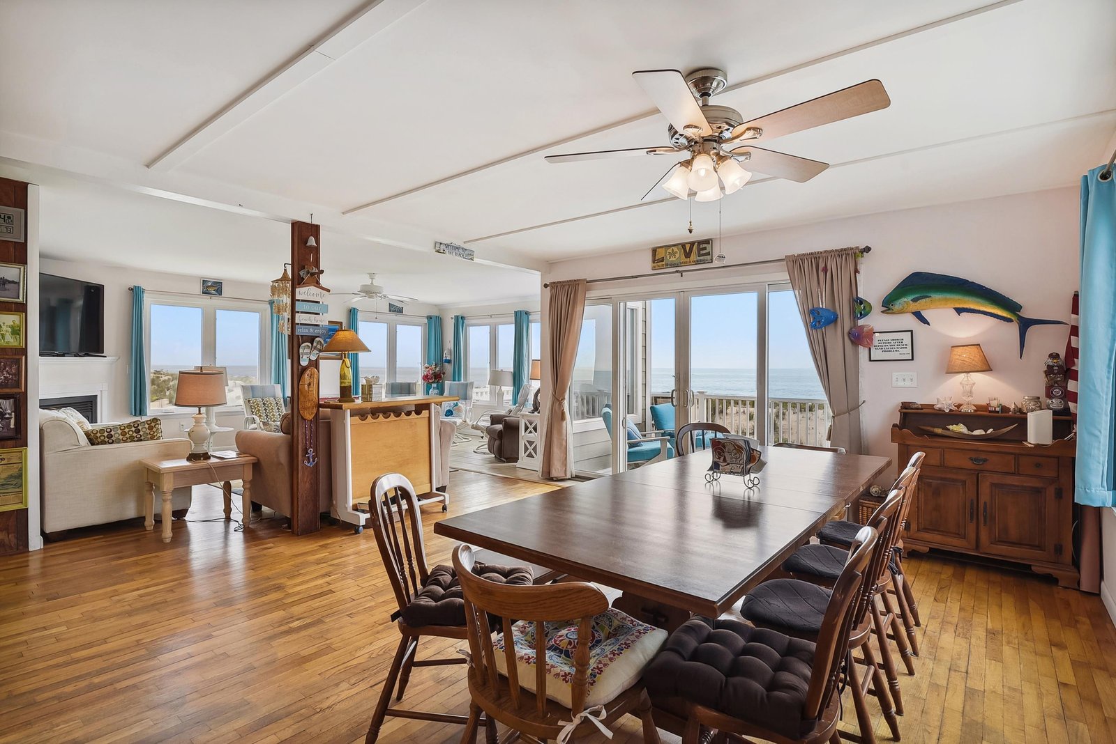 Gather around the dining table while ocean breezes drift through your spacious retreat. The open-concept living space invites you to relax with expansive sea views and coastal charm at every turn.