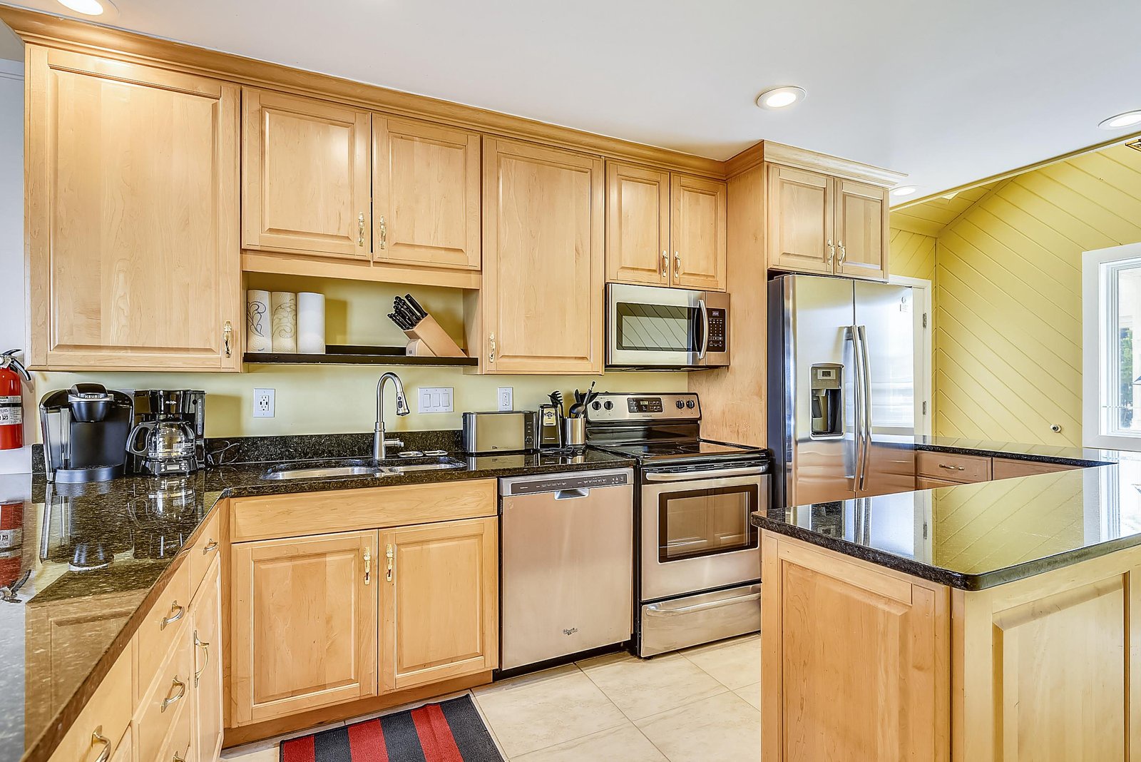 Your fully equipped kitchen features stainless steel appliances, granite countertops, and warm maple cabinetry—everything you need to prepare meals just like home.