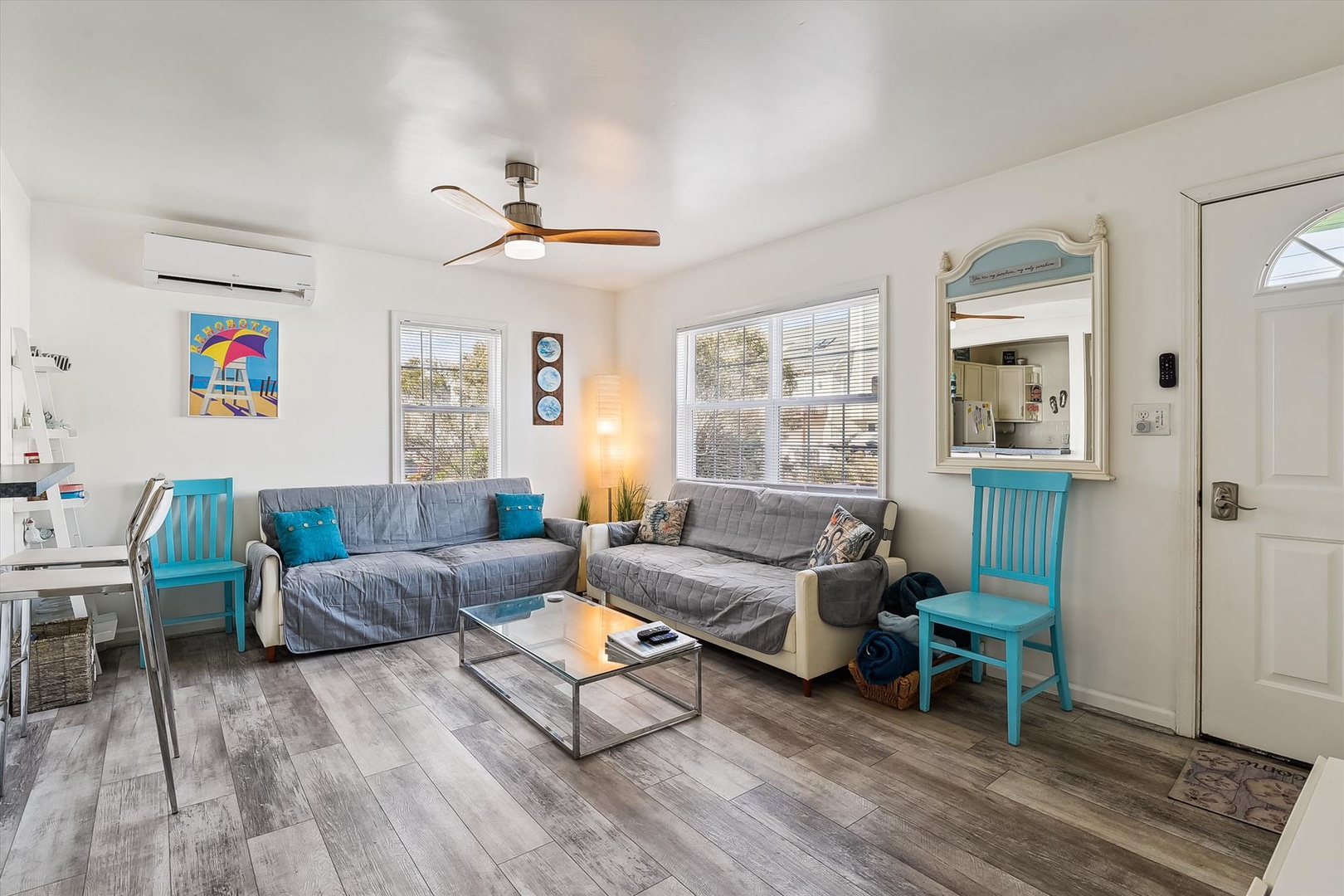 Relax in your bright, airy living space with plush sofas, coastal charm, and cheerful pops of turquoise that bring the beach vibe indoors.