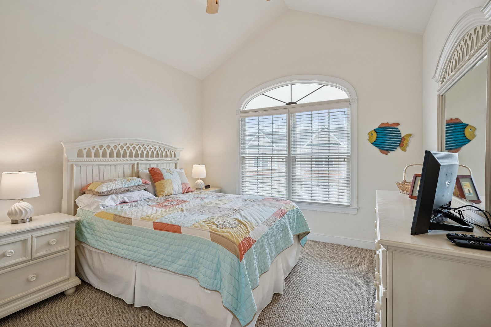 Drift into peaceful dreams in your cheerful bedroom with playful fish decor and soft natural light streaming through arched windows.