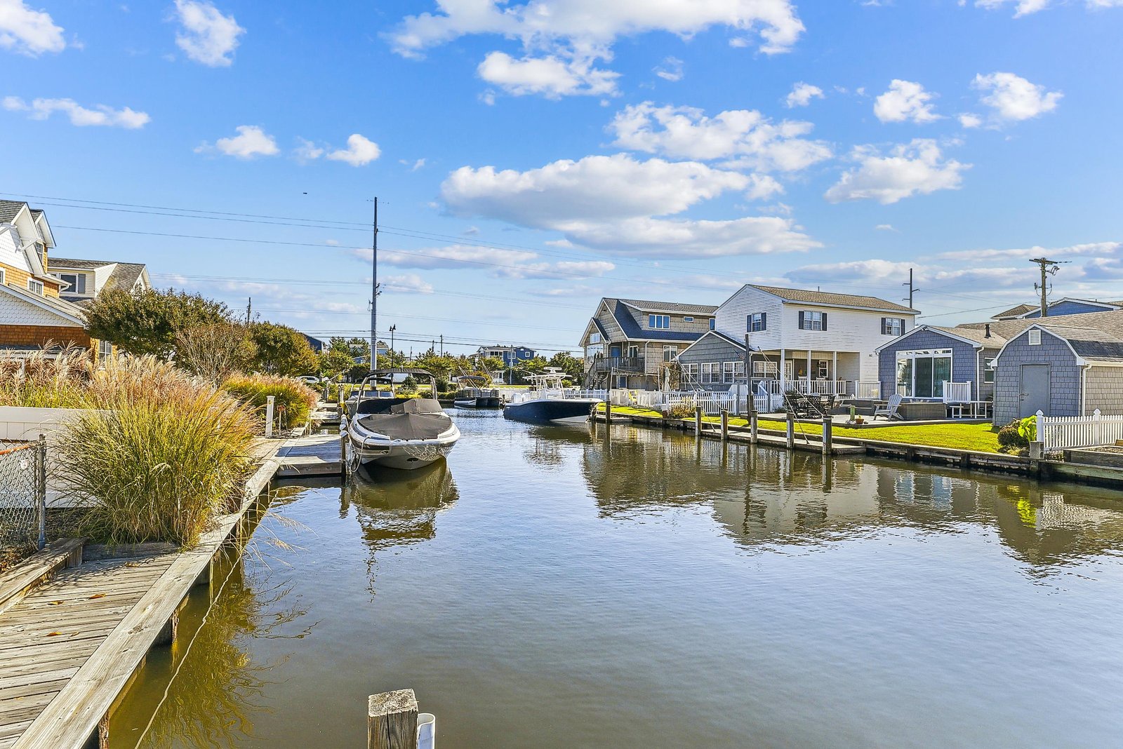 A peaceful canal lined with charming waterfront homes and boat docks marks the arrival to this coastal neighborhood.