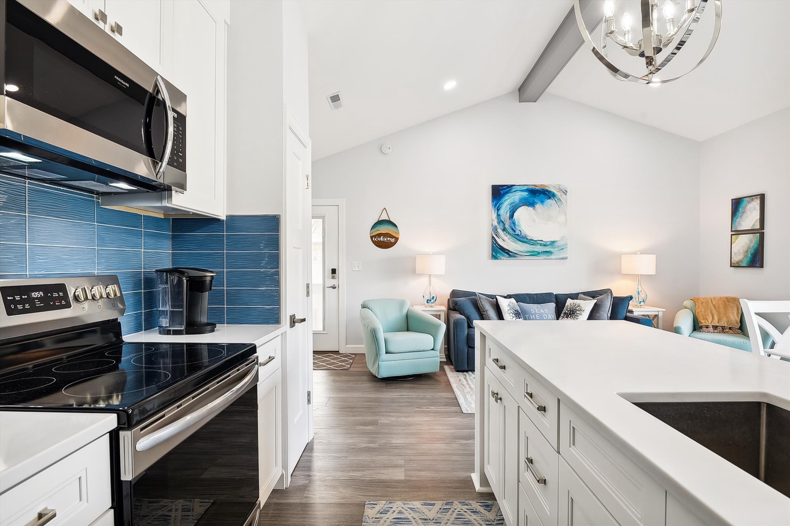 Picture yourself unwinding in this open, airy space where coastal-inspired hues meet sleek modern design. The bright kitchen flows into the inviting living room, perfect for gathering with loved ones.