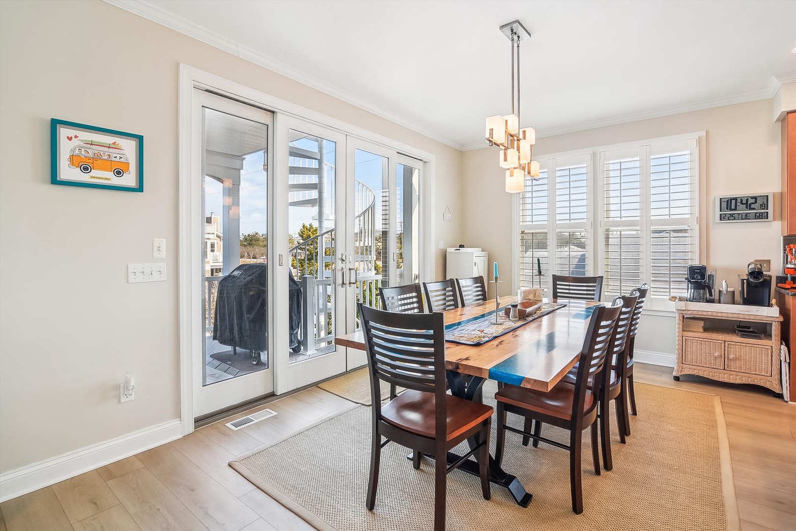 Gather around this bright dining space where meals become memories. Natural light streams through French doors and shuttered windows, creating the perfect spot for your morning coffee or evening dinners together.