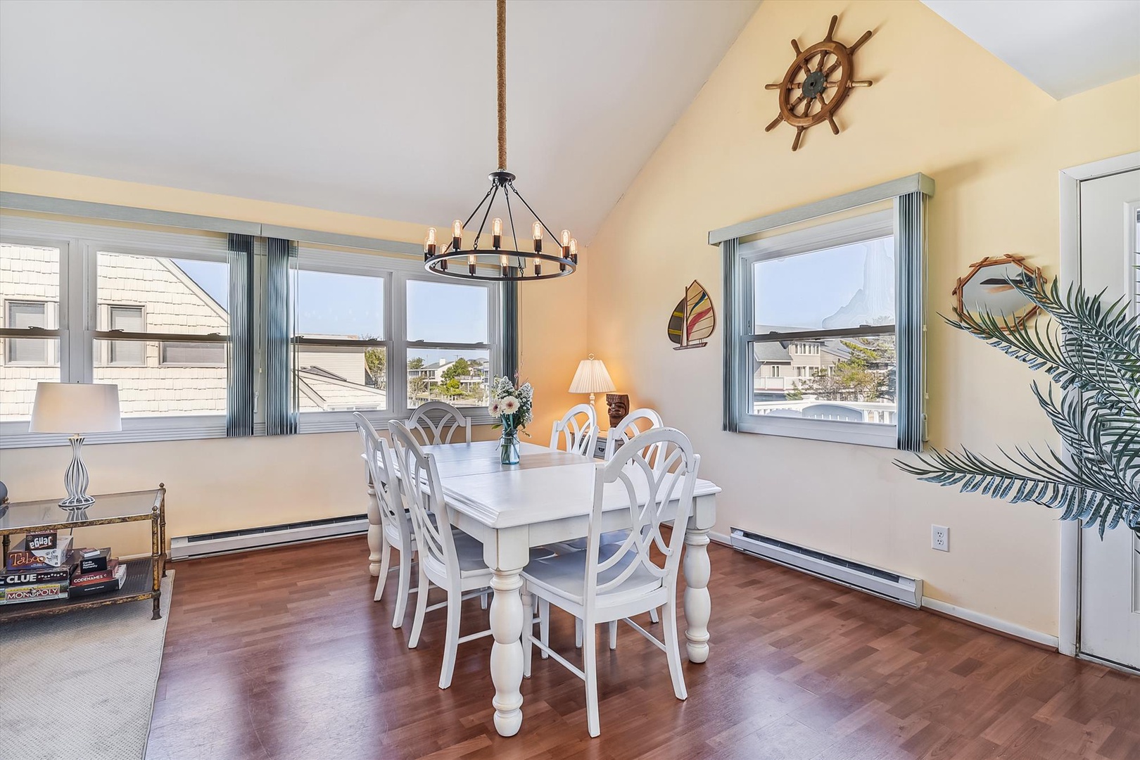 Gather around the bright dining table for memorable meals, framed by coastal charm and natural light streaming through large windows with neighborhood views.