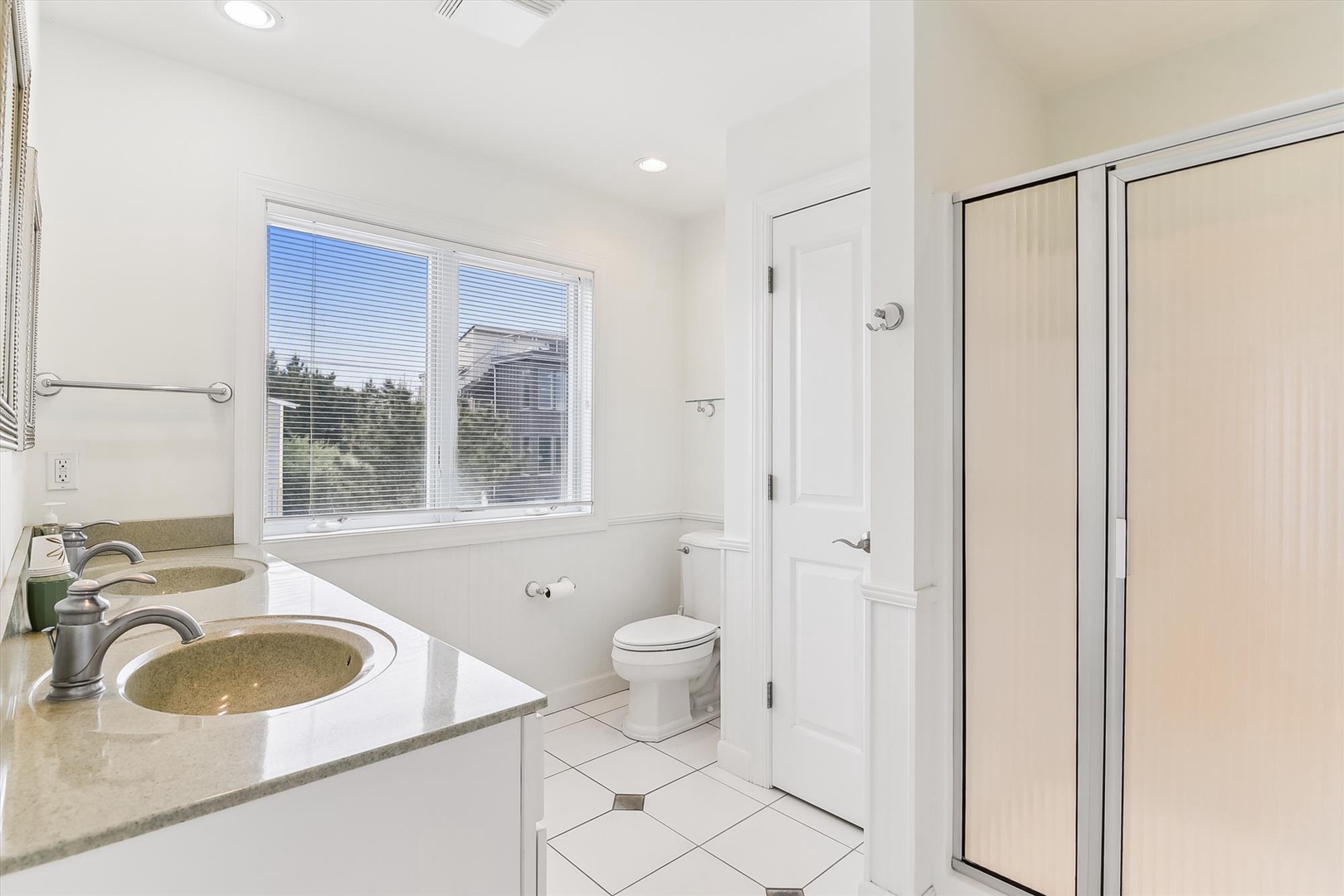 Fresh and spotless, this bathroom offers double sinks, a gleaming shower, and plenty of natural light—your perfect space to refresh and unwind after a day of adventure.