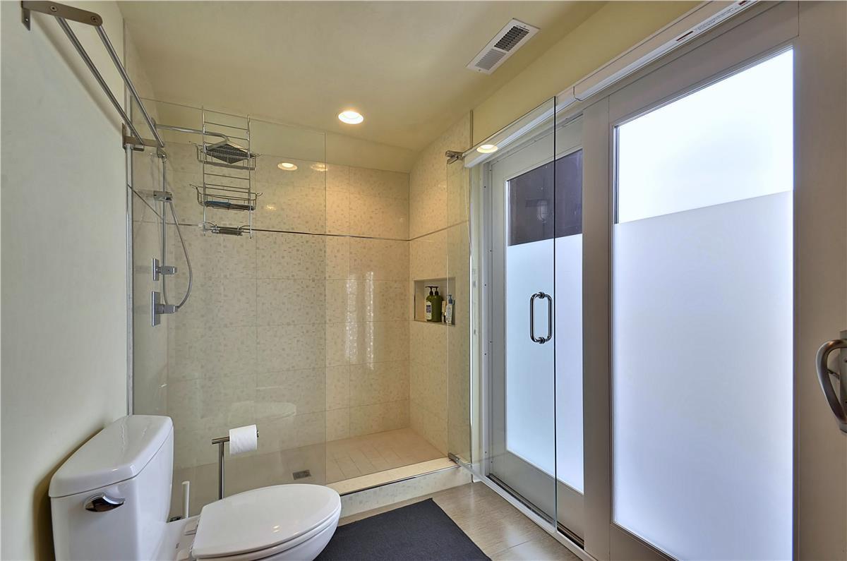 Step into your sleek, modern bathroom with a glass-enclosed shower and warm tile—your personal sanctuary awaits after a day of adventure.