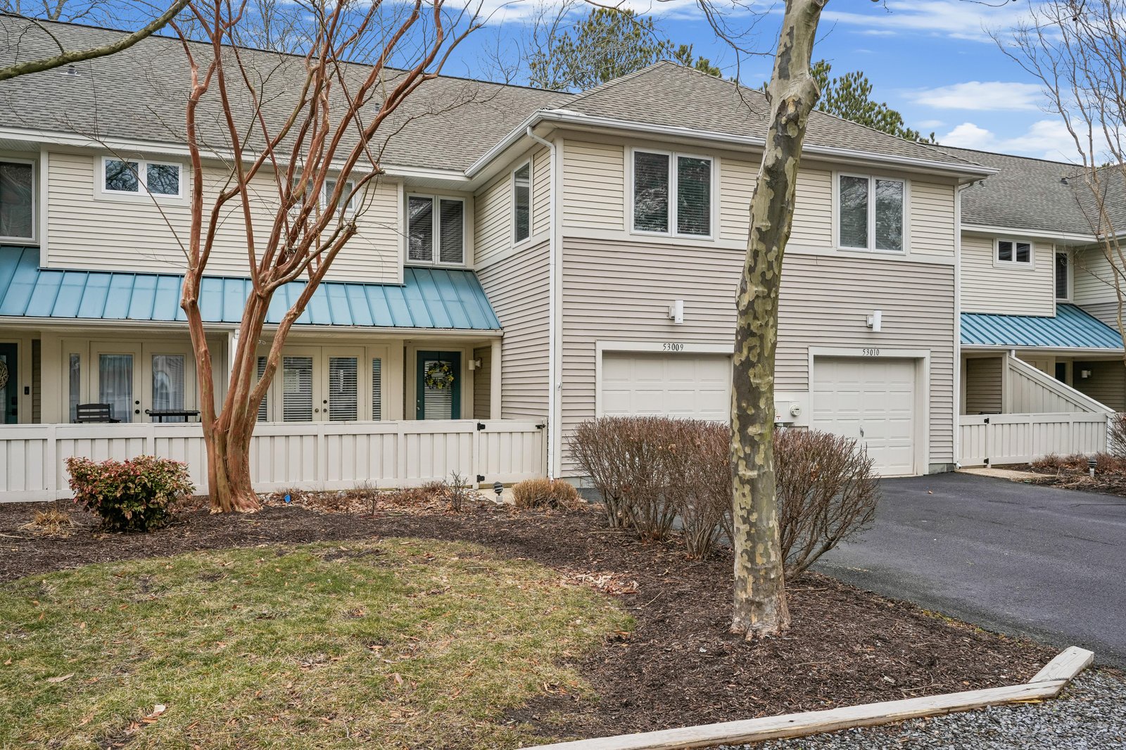 A well-maintained townhome-style vacation rental featuring modern siding, convenient garage access, and mature landscaping in a quiet residential setting.