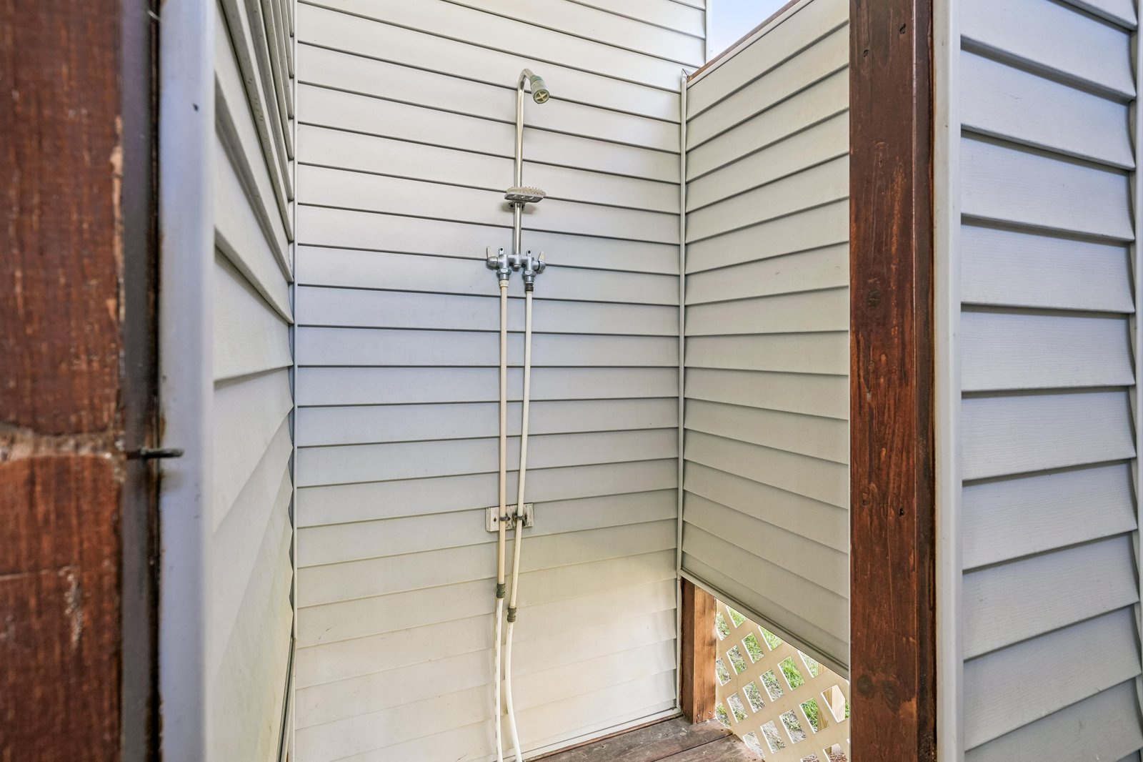 A private outdoor shower tucked in a corner provides a convenient space to rinse off after the beach or pool.