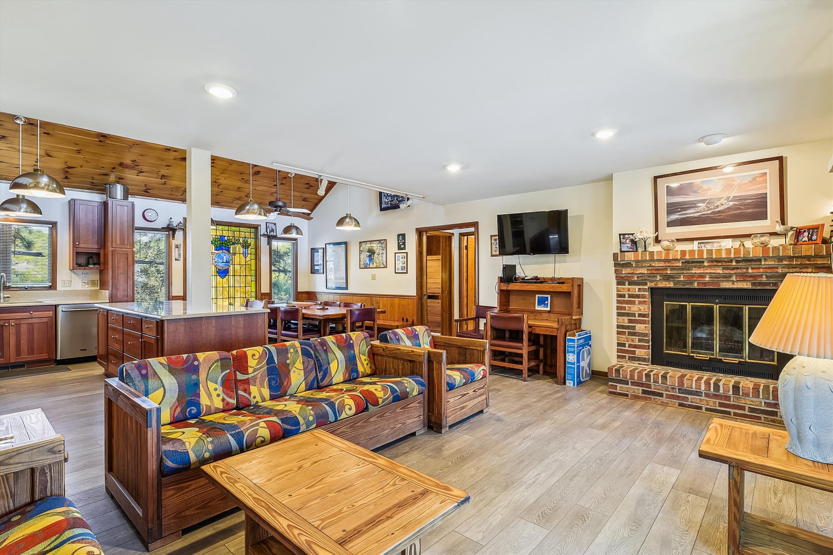 Step into your cozy retreat with vaulted ceilings, warm wood accents, and a charming brick fireplace. The open layout invites you to unwind on vibrant seating or gather around the dining area, while the fully-equipped kitchen makes meal prep a breeze.