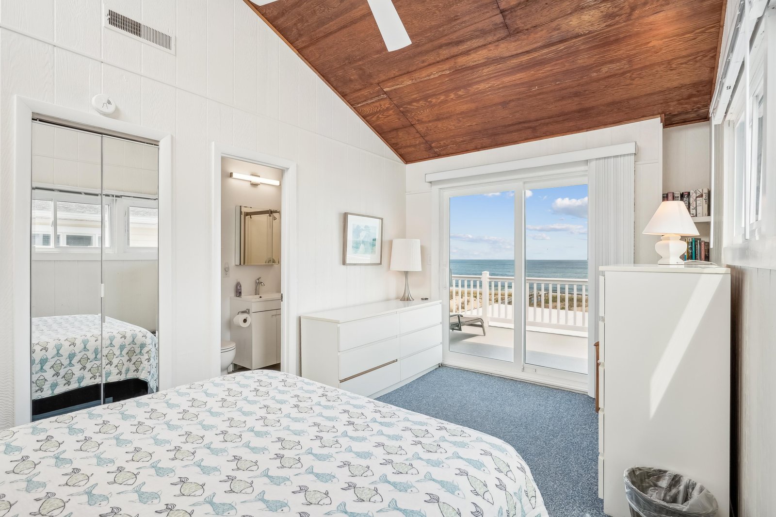 Wake to sunlight streaming through your own oceanfront balcony doors, where calm waves and endless horizon greet you. This peaceful retreat features warm wood ceilings and a cozy coastal charm you'll never want to leave.