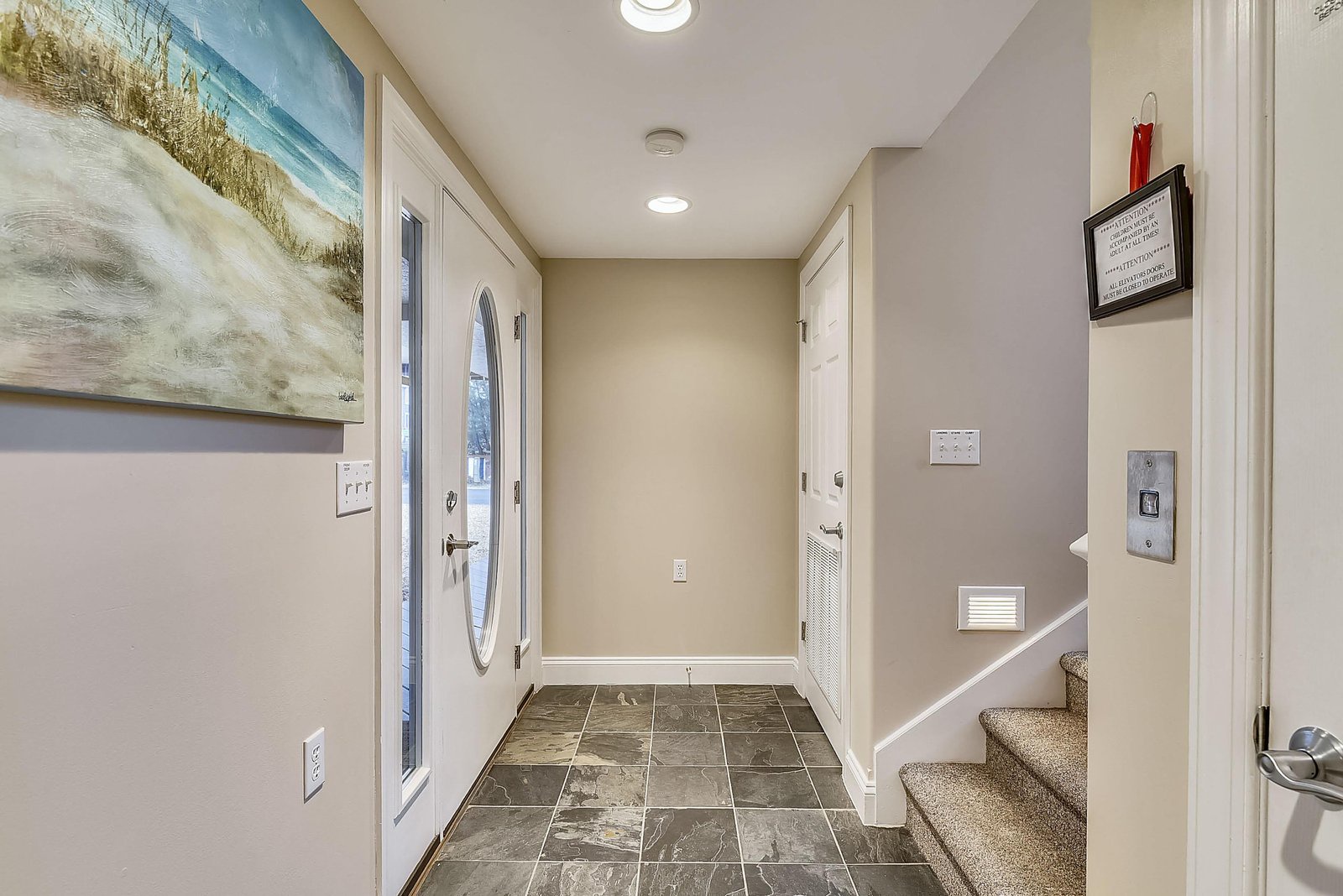Step into your coastal retreat through this welcoming entryway with beautiful tile floors and warm lighting. The beachy art sets a relaxed, vacation-ready tone the moment you arrive.