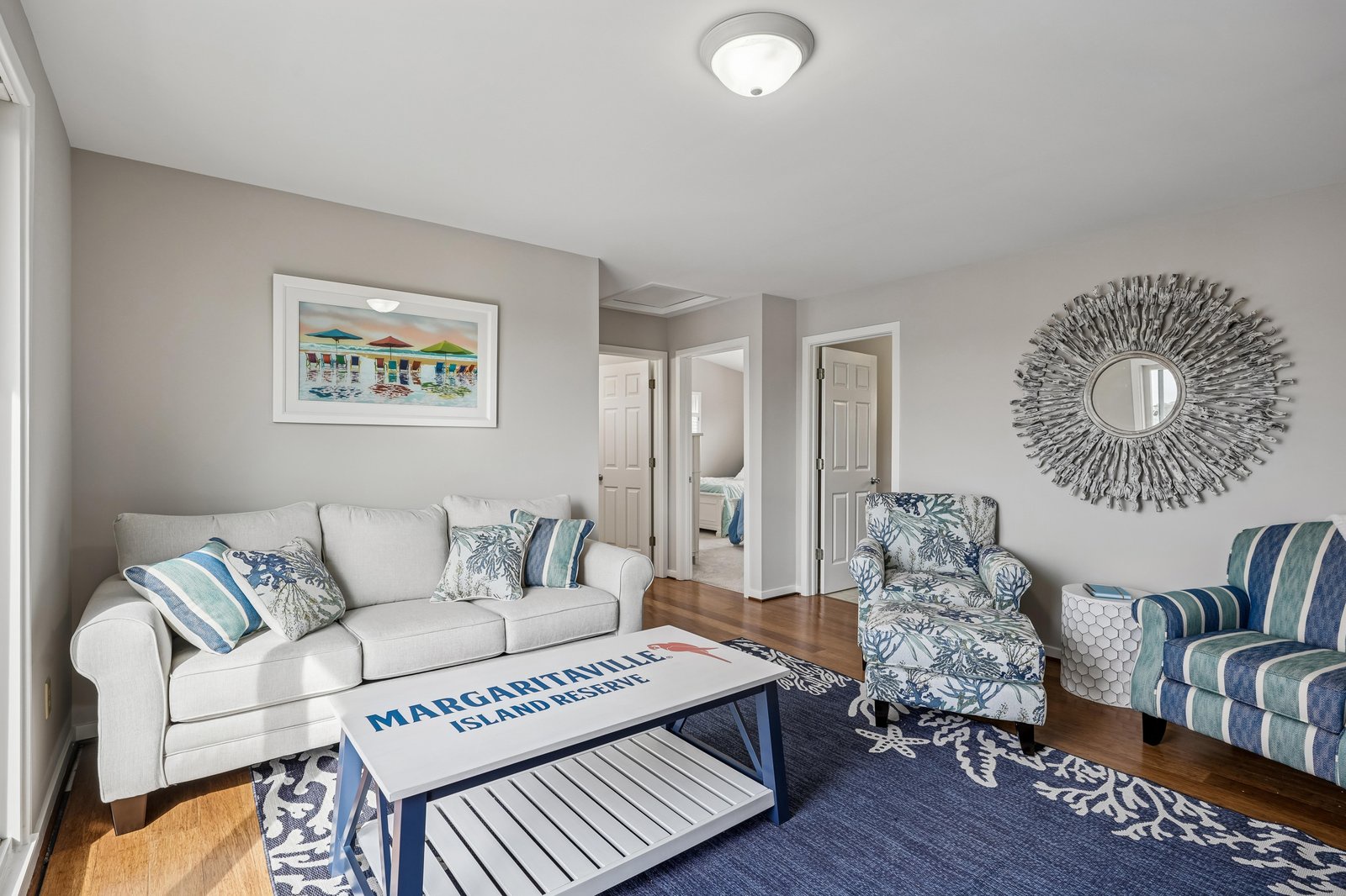 Relax in your inviting living space with plush coastal-themed seating, warm hardwood floors, and charming nautical details that create a peaceful seaside retreat for your getaway.