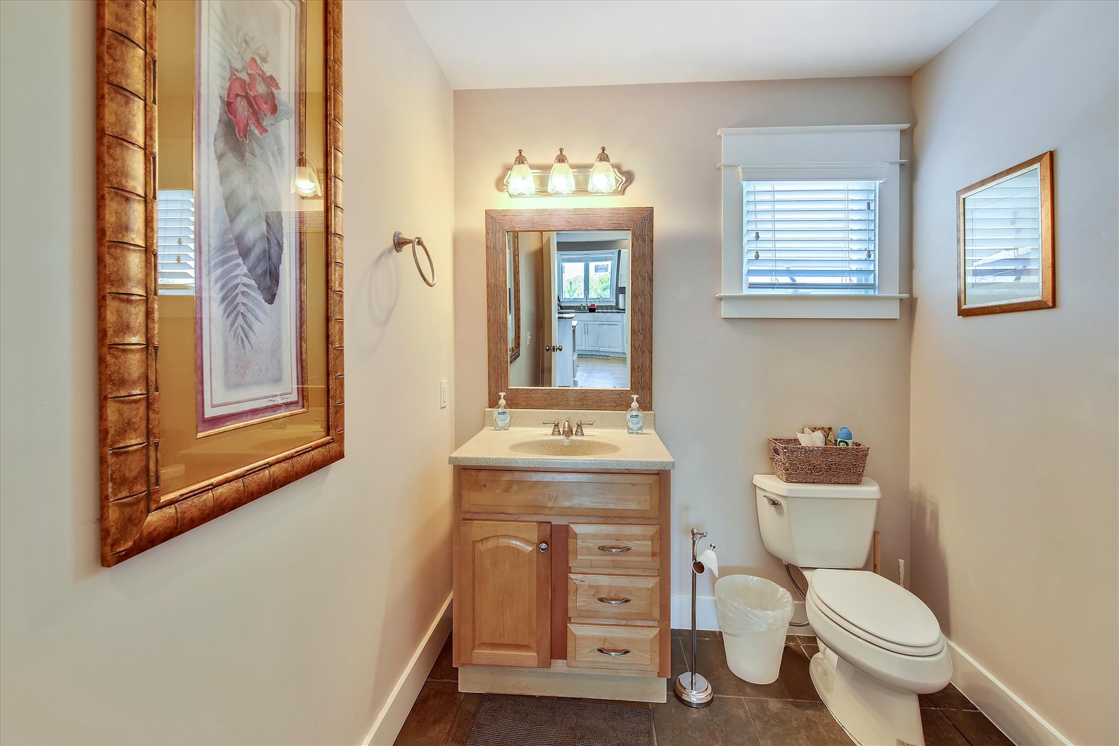 Freshen up in this beautifully appointed bathroom with warm wood vanity, natural light from bright windows, and coastal-inspired décor that creates your peaceful retreat.
