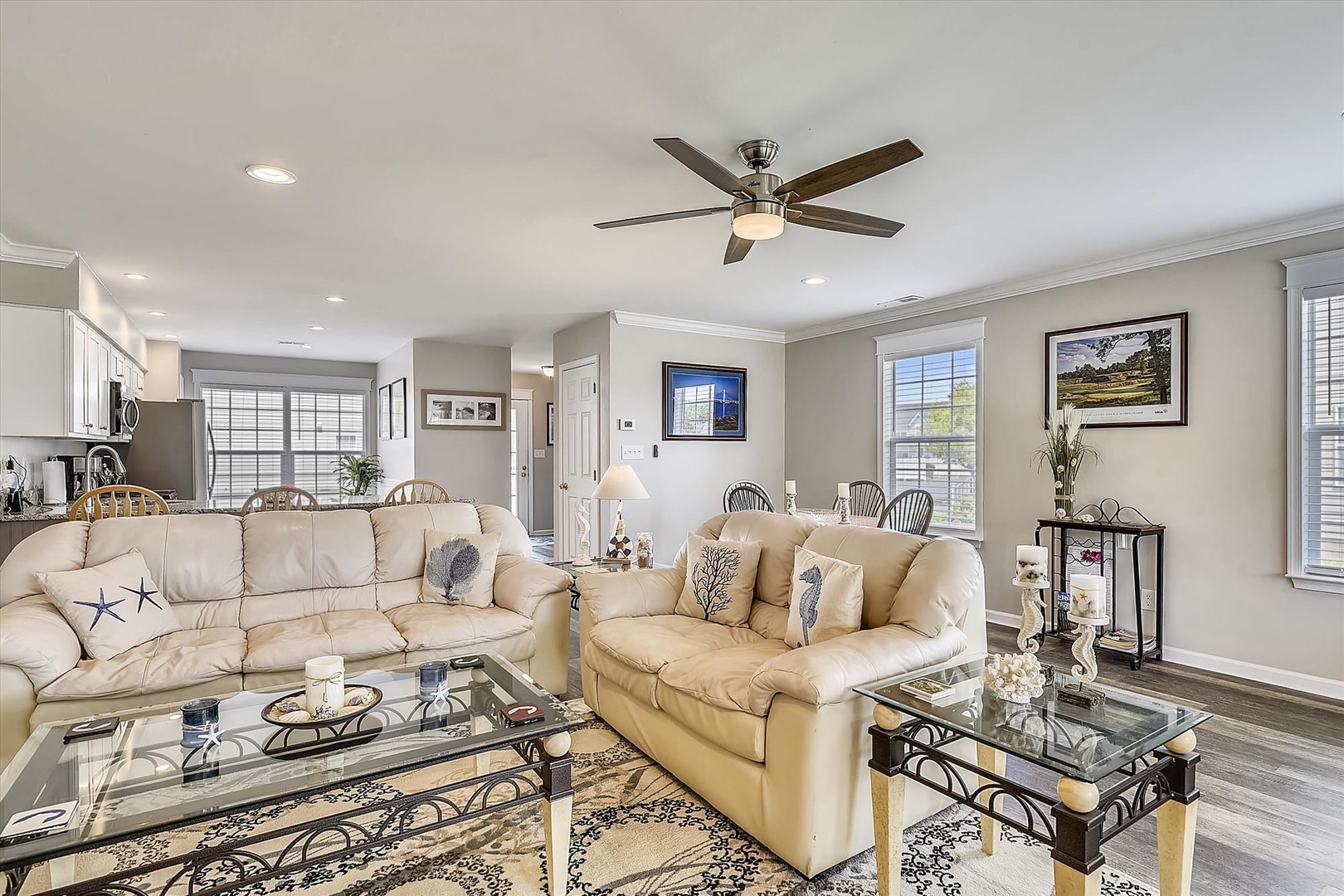 Sink into plush seating under soft lighting and a gentle ceiling fan. Your bright, open living space flows seamlessly into the kitchen and dining area, perfect for relaxing or gathering with loved ones.