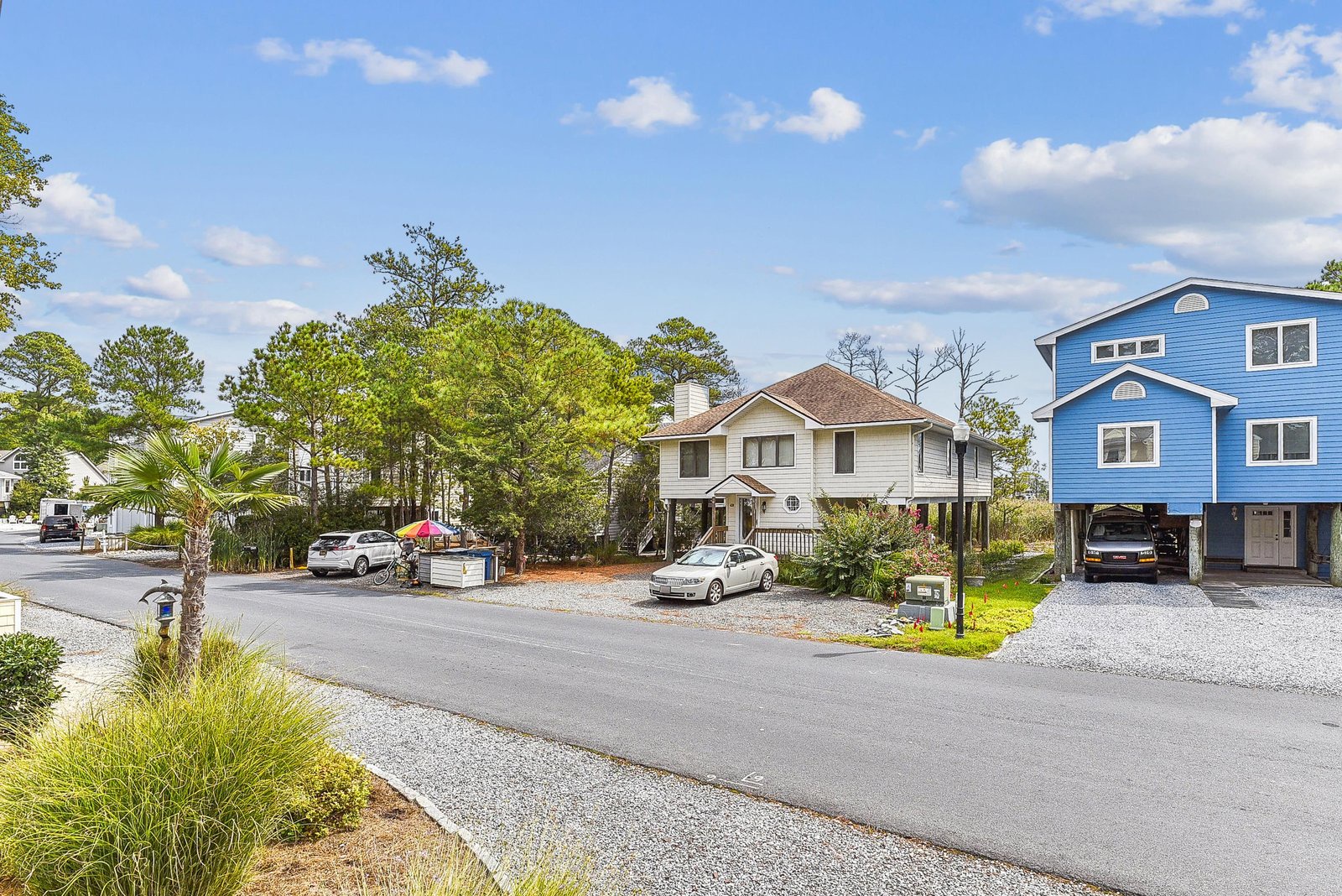 The property sits in a quiet residential neighborhood with coastal charm, featuring mature trees and convenient parking.