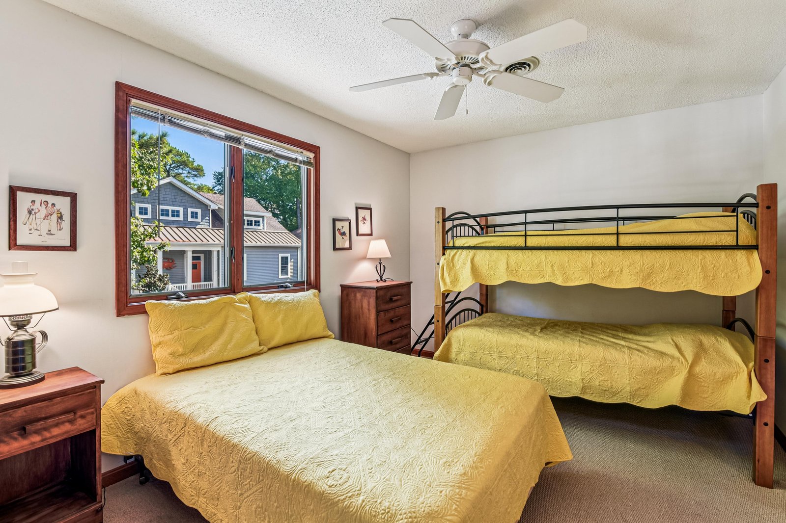 Bright and cheerful bedroom with sunny yellow bedding, a full bed plus bunk beds—perfect for families or groups traveling together.