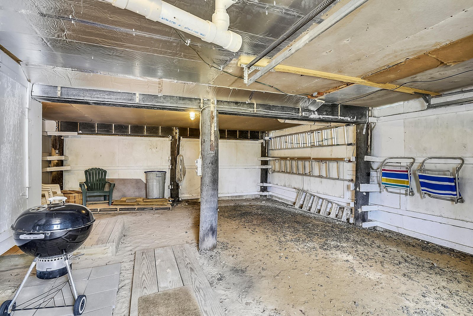 This private space offers plenty of room for your outdoor gear and beach essentials, with shelving for organized storage and a charcoal grill ready for your cookout plans.