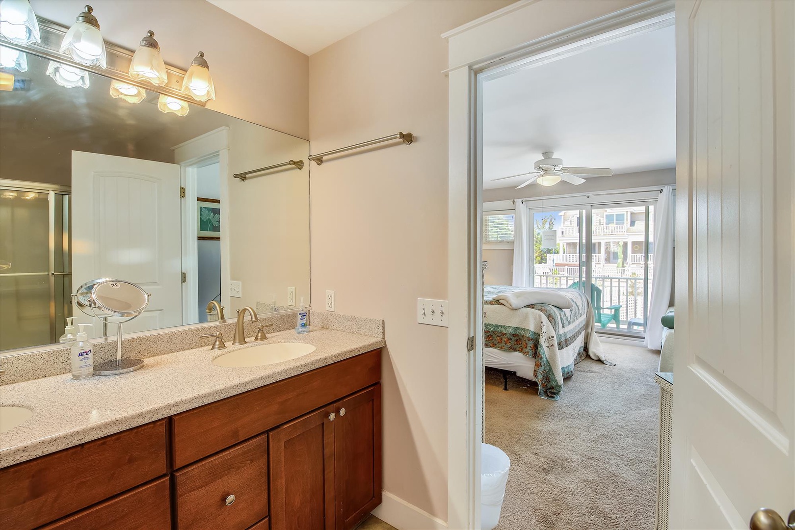 Wake up and refresh in your private en-suite bathroom with ample counter space, warm lighting, and convenient access to your sunny bedroom with balcony views.
