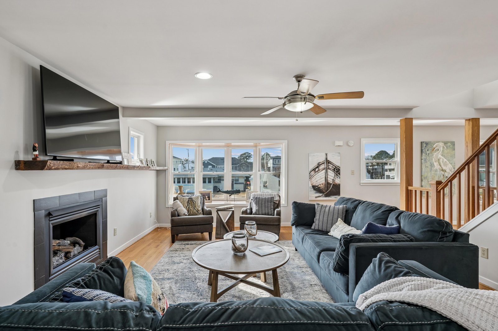 Settle into plush seating by the fireplace, relax under the ceiling fan, and enjoy waterfront views framing your coastal getaway.