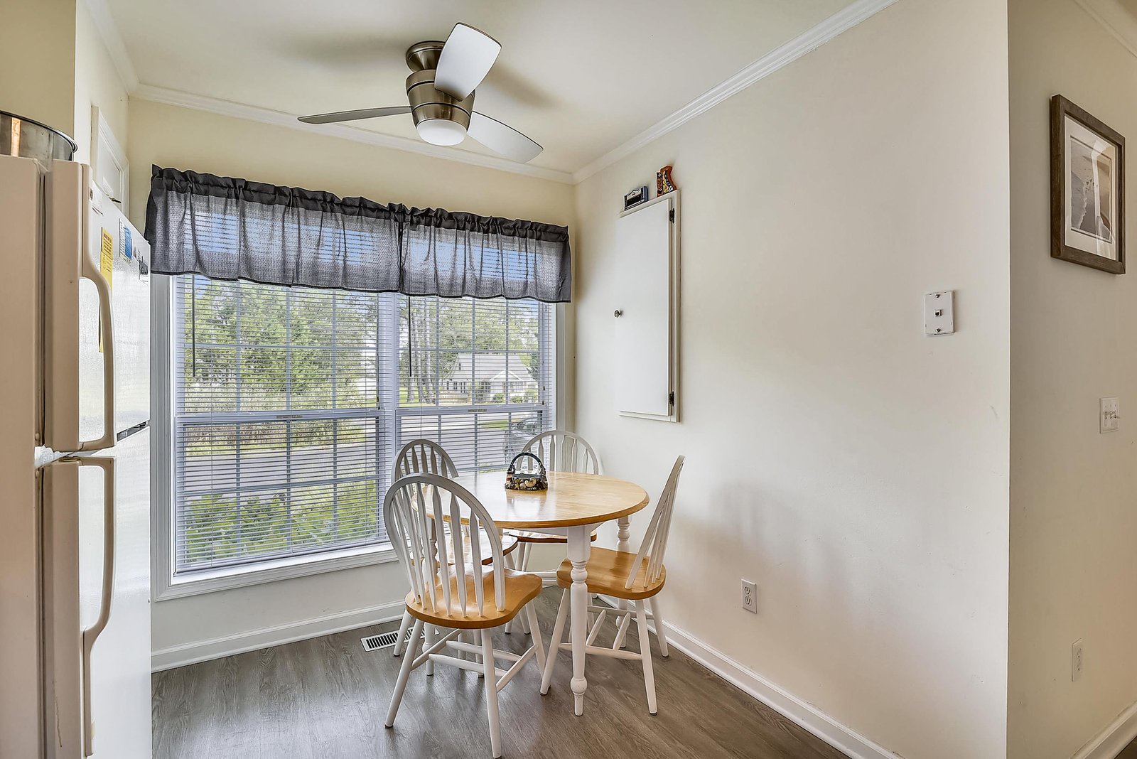 Settle in for breakfast or coffee at your cozy dining nook, bathed in natural light from the large window and cooled by a ceiling fan overhead.