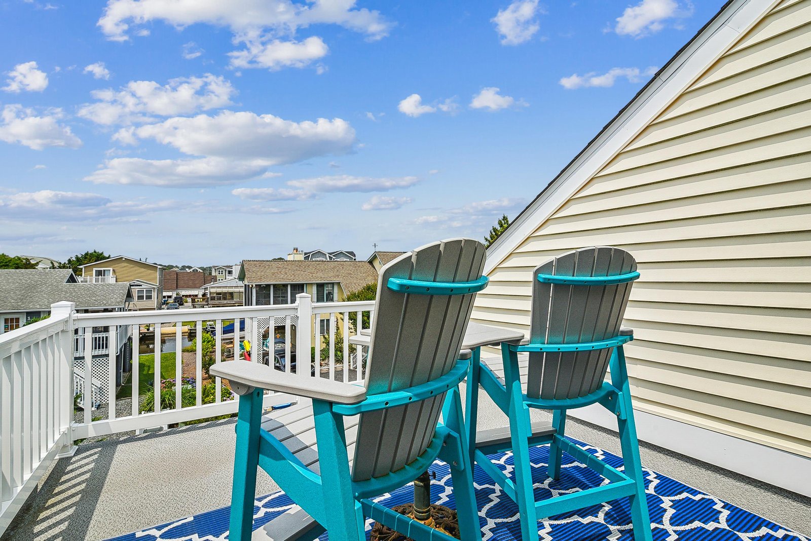 Settle into these inviting Adirondack chairs on your private balcony and soak in the sunny blue skies and peaceful neighborhood views—your perfect spot to unwind with morning coffee or evening conversation.