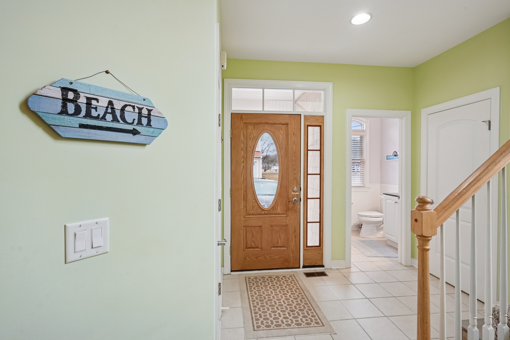Step into your beach getaway through this bright, welcoming entrance with charming coastal décor that sets the perfect vacation mood.