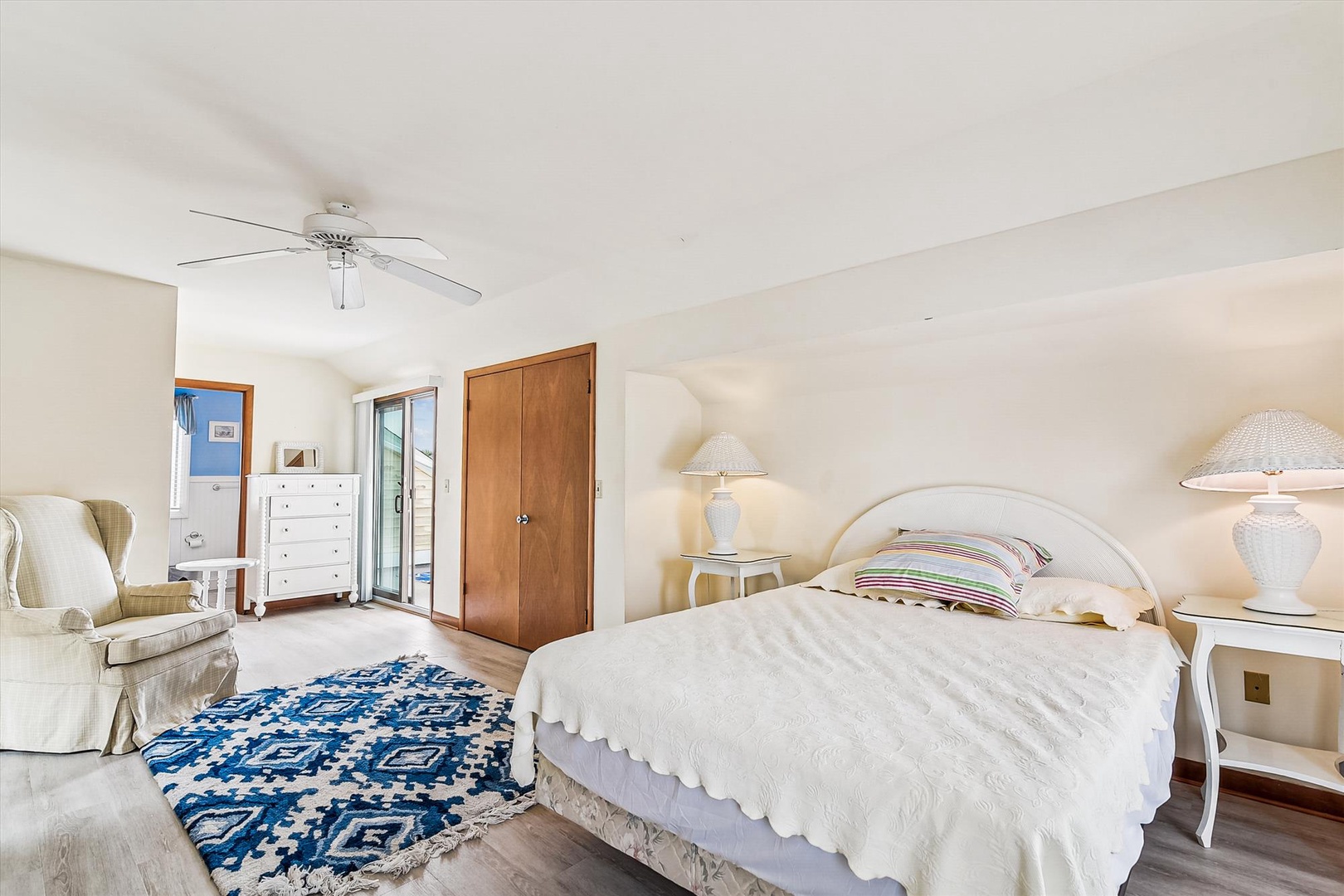 Unwind in your peaceful bedroom, where soft linens, cozy seating, and coastal charm create the perfect retreat for restful nights and lazy mornings.