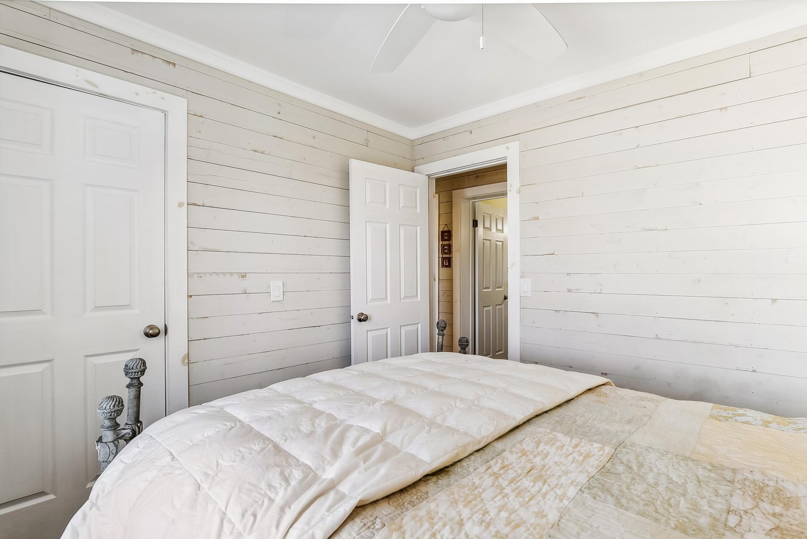 Your peaceful retreat awaits with soft linens and whitewashed shiplap walls that wrap you in serene farmhouse charm.