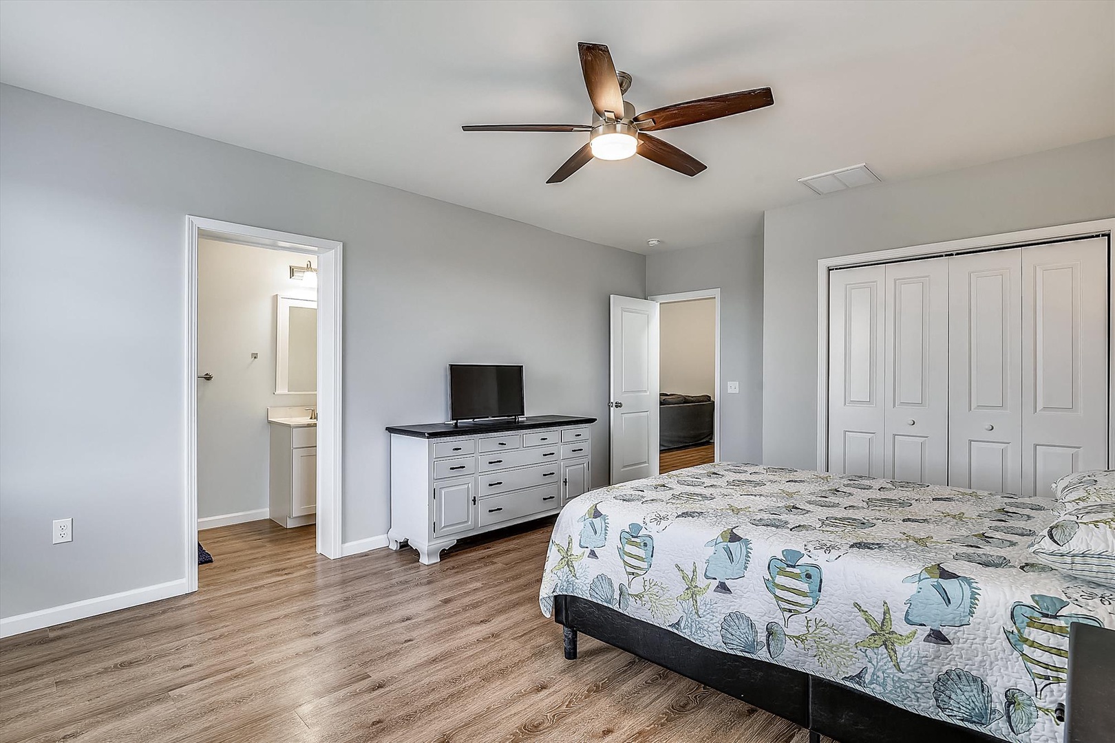 Wake up in your spacious retreat with soft gray walls, warm wood floors, and gentle ceiling fan breezes. Your private ensuite awaits, plus plenty of storage for all your vacation essentials.