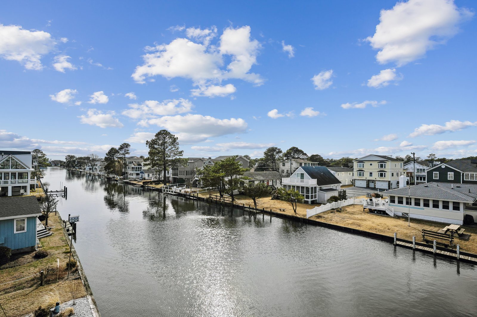 Elevated view of a peaceful waterfront community with private docks and canal access, offering a serene coastal setting for your stay.