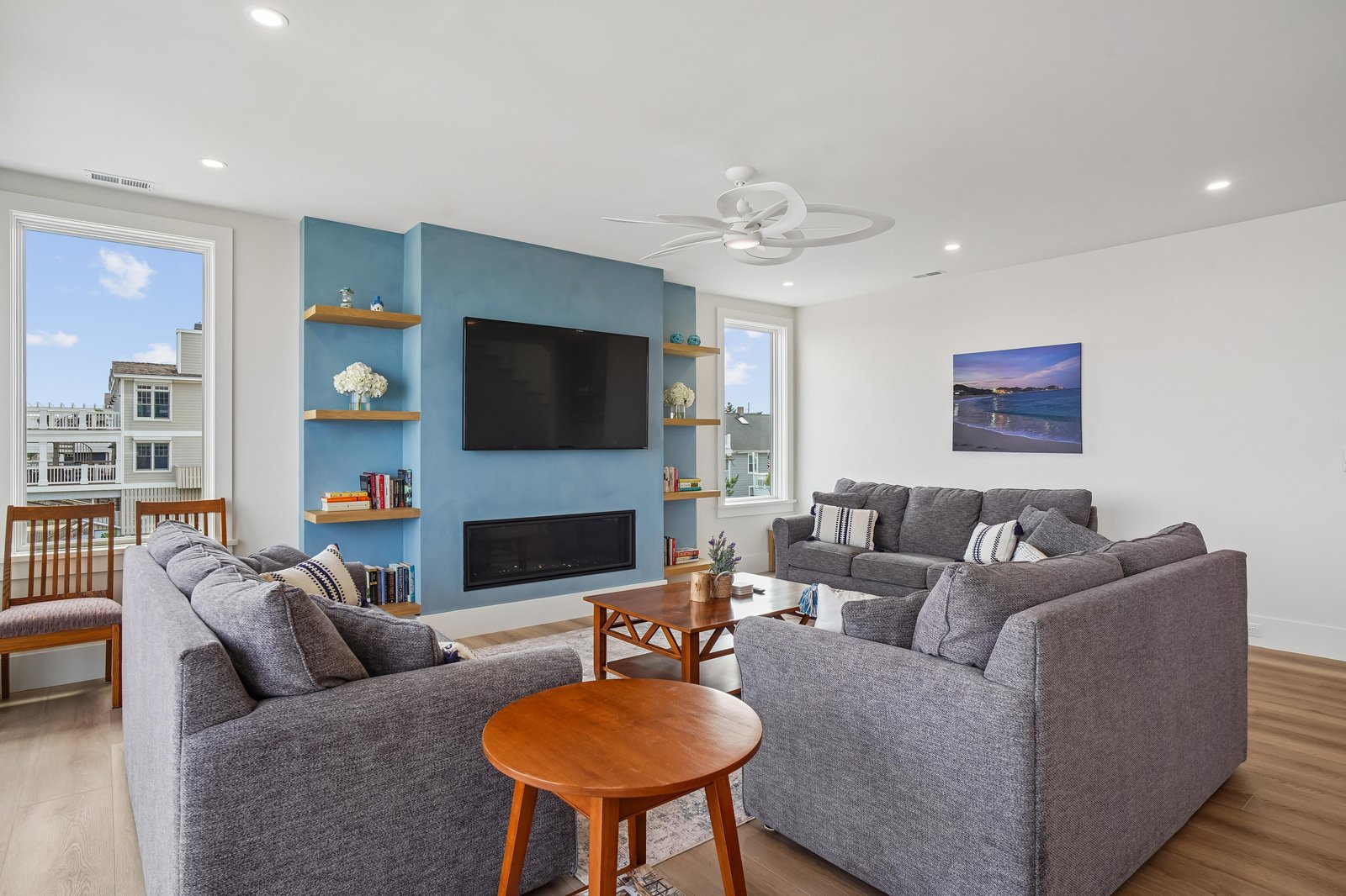 Unwind in your spacious living room with plush seating, a sleek fireplace, and natural light streaming through large windows. Perfect for cozy evenings or lively gatherings with friends and family.