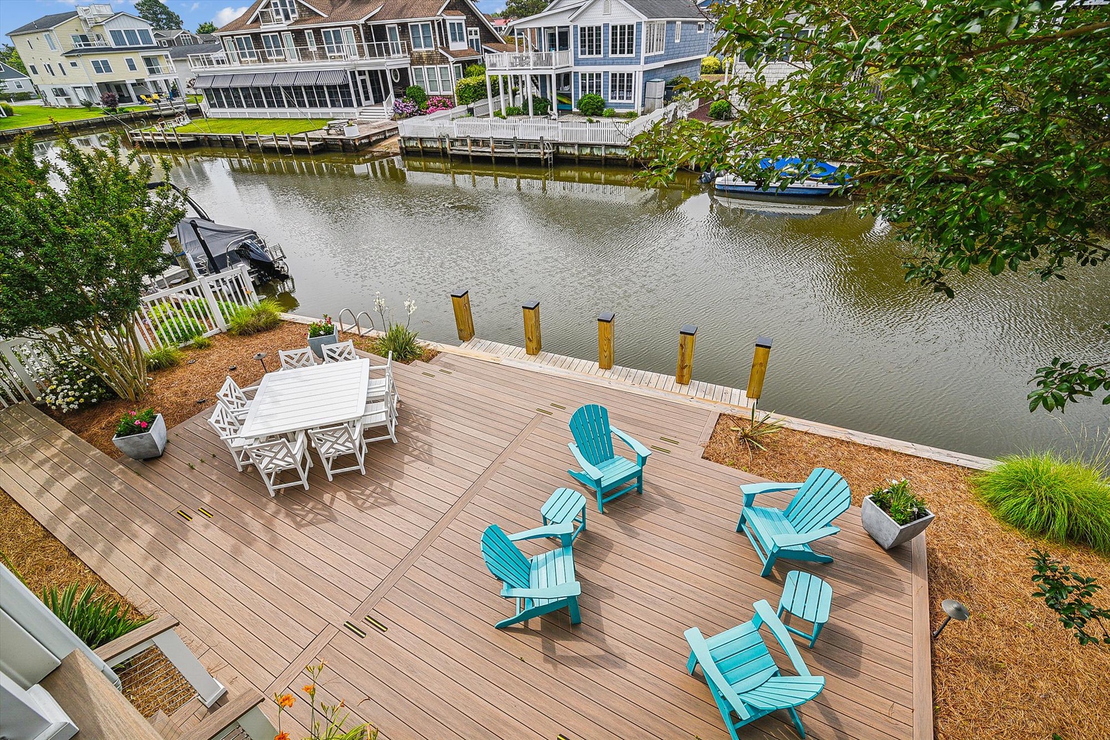This waterfront deck overlooks a serene canal-front setting and features outdoor seating areas perfect for enjoying peaceful summer mornings and warm evenings by the water.