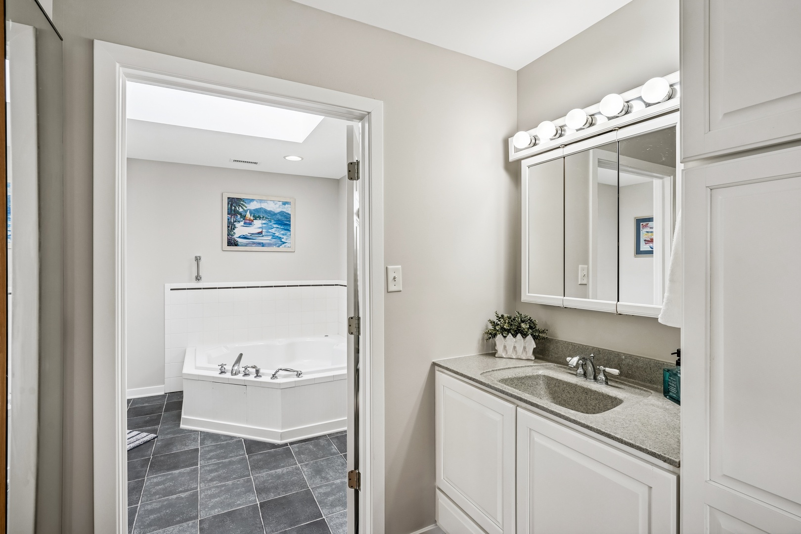 Unwind in your spa-like bathroom with a sleek vanity and soaking tub beyond the doorway.