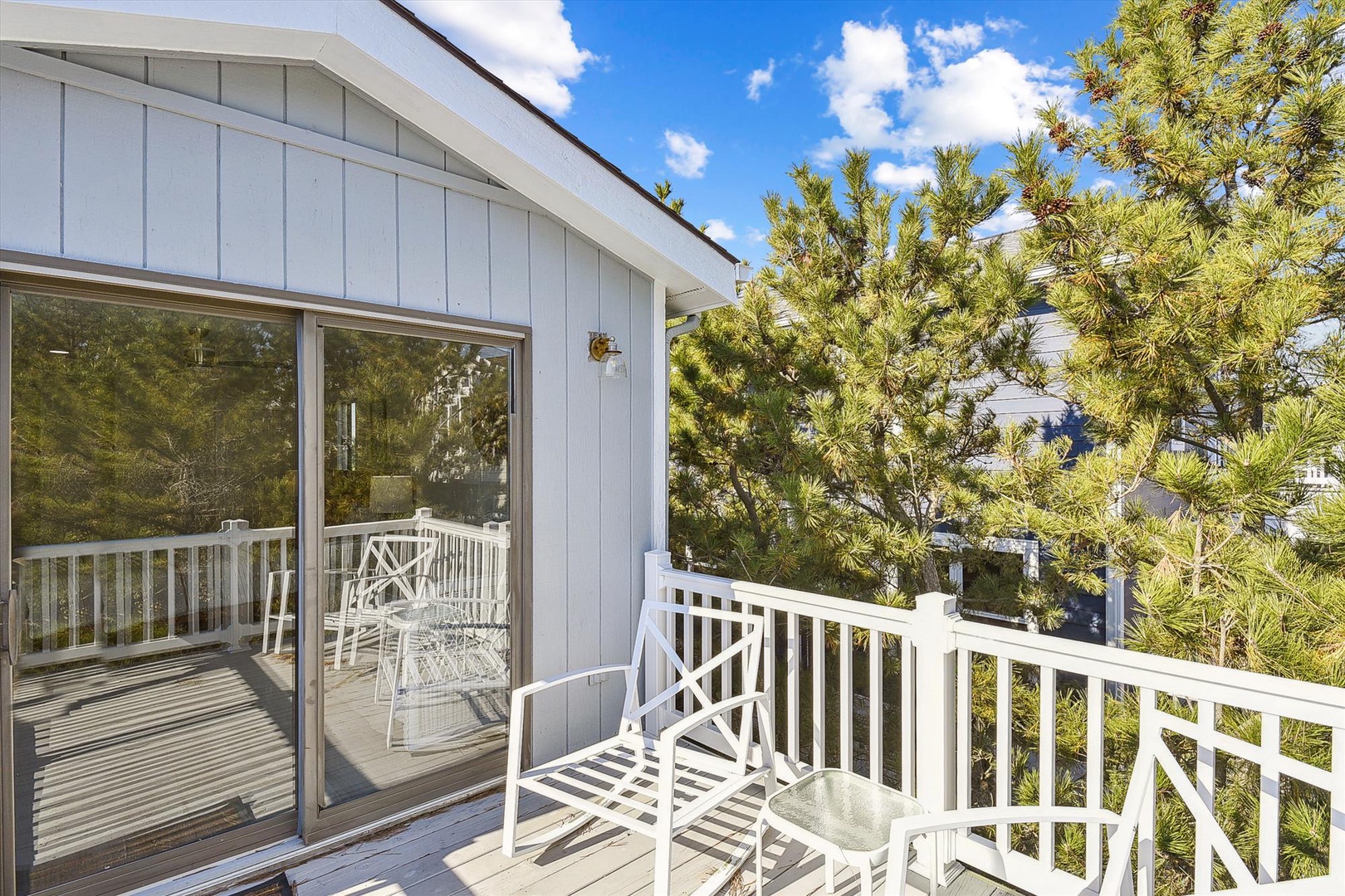 Enjoy your morning coffee on the private balcony with fresh pine views and bright coastal sunshine, perfect for unwinding after a day at the beach.