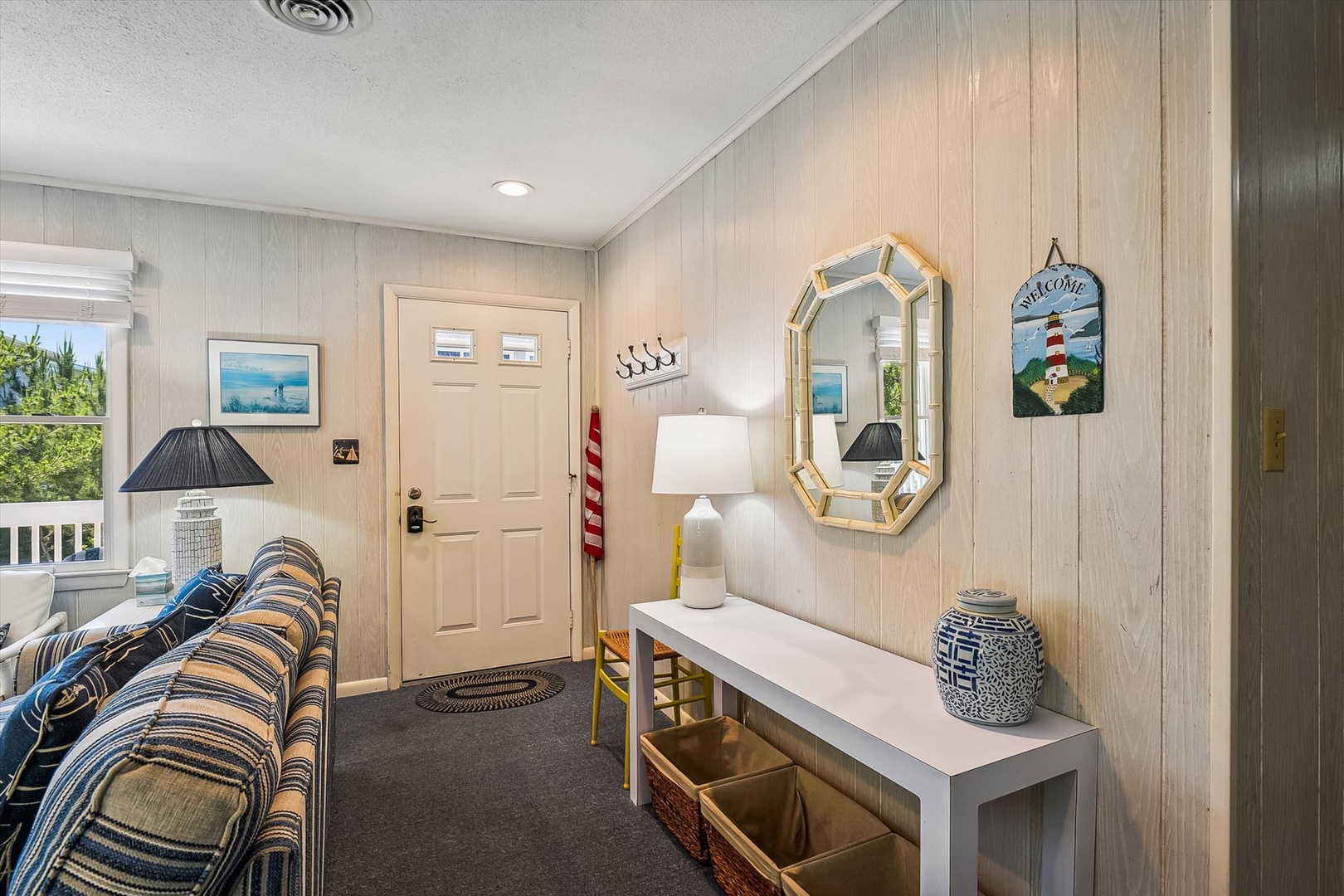 Cozy coastal entryway with nautical decor welcomes you home. Bright, inviting space with beach-inspired touches and charming lighthouse accents sets a relaxing tone for your stay.