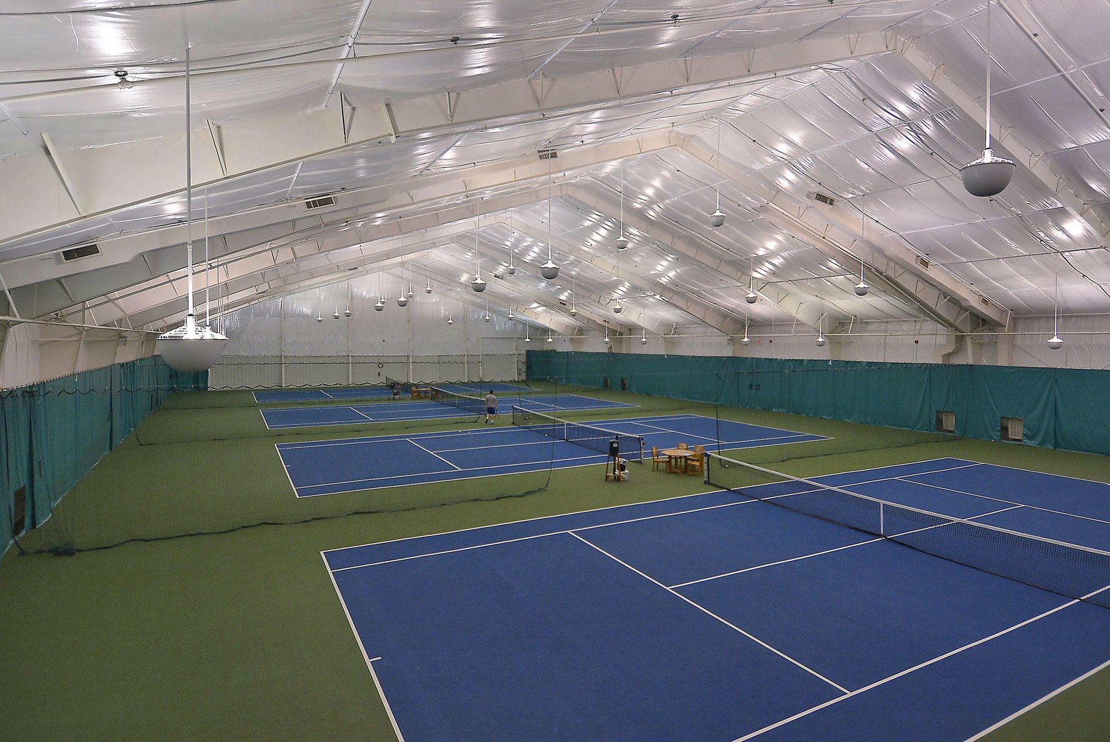 Indoor tennis courts with pristine blue playing surfaces await your next match, whether you're a beginner or seasoned player.
