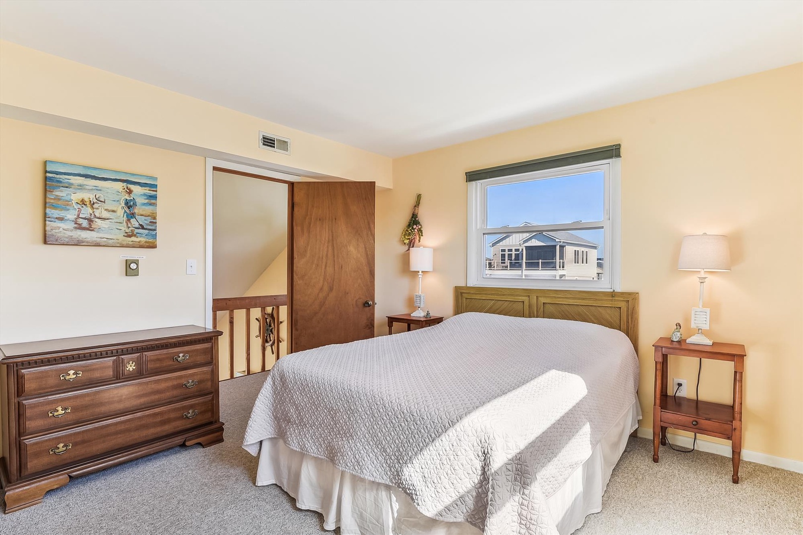 Drift off in this sunlit bedroom with warm coastal charm and a comfy bed awaiting your restful nights. You'll love waking up to peaceful views and the cozy, beachy vibe.