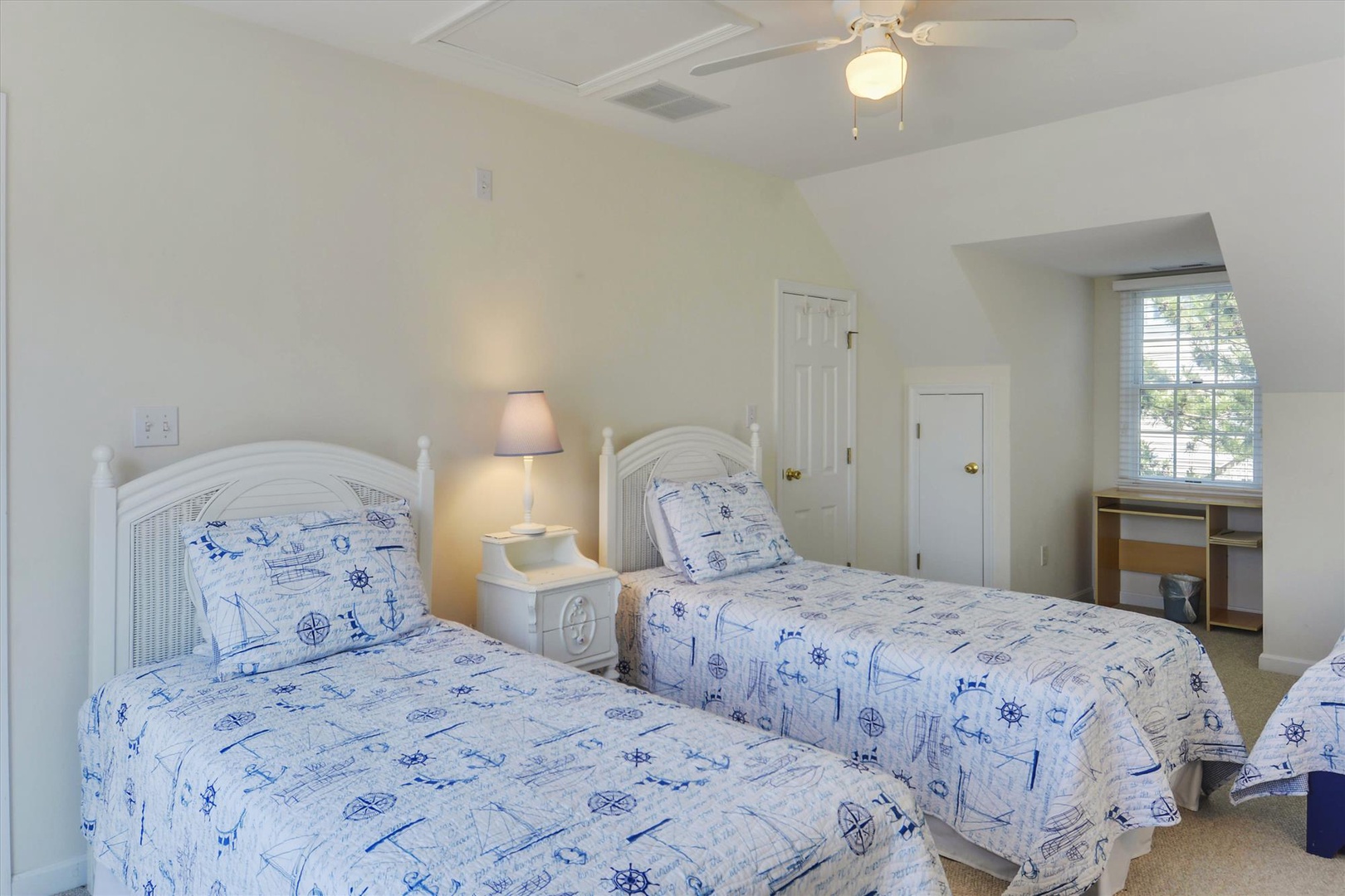 Drift off in this bright, nautical-themed bedroom with comfortable twin beds, perfect for sharing stories and laughter after a day of coastal adventures.